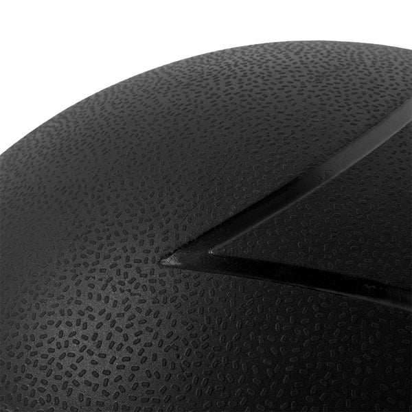 A close-up of a textured black surface closely resembling the durable rubber of SMAI's Slam Ball Monster Set, available in 60kg, 70kg, and 80kg variants. The surface features a V-shaped groove running diagonally across it, appearing rough with small raised dots that provide a tactile feel perfect for Strongman training. The lighting accentuates the groove, enhancing contrast and detail.