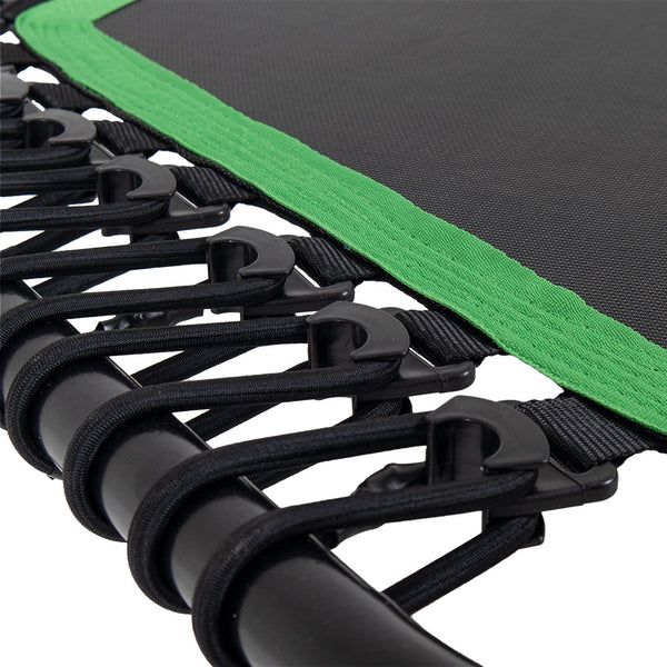 Close-up of the Rebounder Mini Trampoline 50" edge by SMAI, highlighting the black metal frame, elastic bands, and hooks. The trampoline mat is bordered with a green fabric strip, while bungee cords provide additional support.