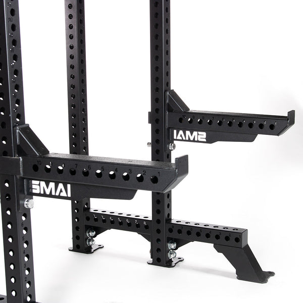 Close-up of a black adjustable gym rack with a quick release safety pin system and multiple holes for customization. Featuring "SMAI" on the supports, it also includes Safety Spotter Arms (Pair) - Vanta Series for added security. Set against a plain white background, the rack ensures reliability and versatility.