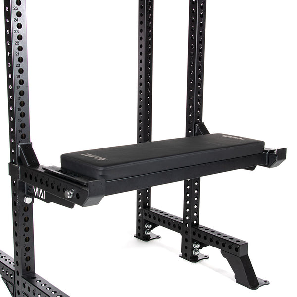 side view of utility bench attached to half rack using the spotting arms