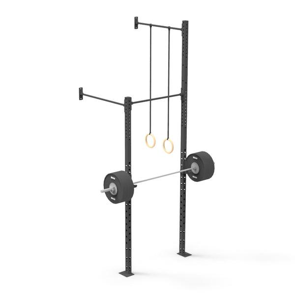 The Wall Mounted Rig - 1 Squat Cell with Bridge - X-Frame from No Sync To Channel Engine is a black power rack designed for wall mounting. It includes a pull-up bar, gymnastic rings, and a weightlifting bar with plates, making it an excellent modular option for strength training and functional fitness exercises. It's ideal for those wanting to add commercial-grade equipment to their home gym setup.