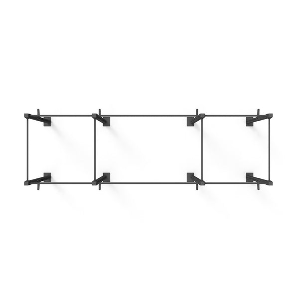 The Rig - 4 Squat Cells by SMAI is a minimalist black metal wall shelf constructed from steel tubing, featuring four rectangular sections. Mounted against a white background, each section includes two side brackets for support, offering a modern and modular design ideal for any space.